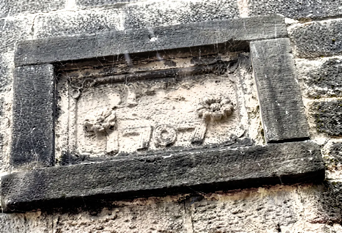 A weathered 1707 datestone carved into the stonework